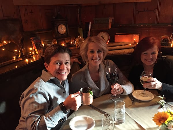 Michelle (center) enjoys a meal with her wife, Tena Clark  (left) and Michelle's  mother (right).