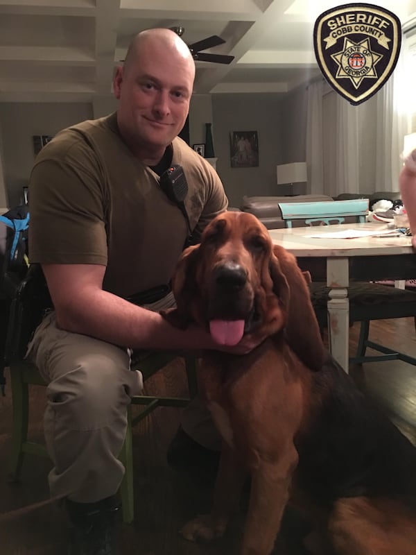 Cobb County sheriff's deputy Scott Berger (left) and Hank pose for a picture.