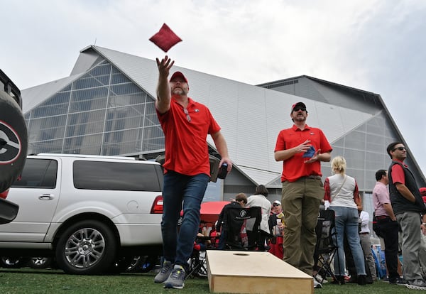 December 4, 2021 Atlanta - Georgia fans Toby Fletcher (left) and Jason Bobertz enjoy tailgating at The Home Depot Backyard prior to the Southeastern Conference championship NCAA college football game between Georgia and Alabama at Mercedes-Benz Stadium in Atlanta on Saturday, December 4, 2021. (Hyosub Shin / Hyosub.Shin@ajc.com)