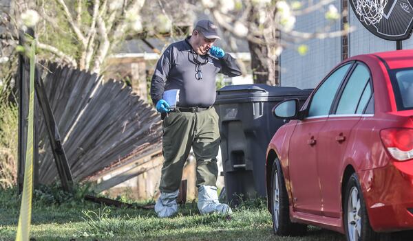 Investigators collect evidence at a home on Tidwell Circle in Forsyth County where two men and a 17-year-old were shot Thursday morning. The teenager is the only survivor.