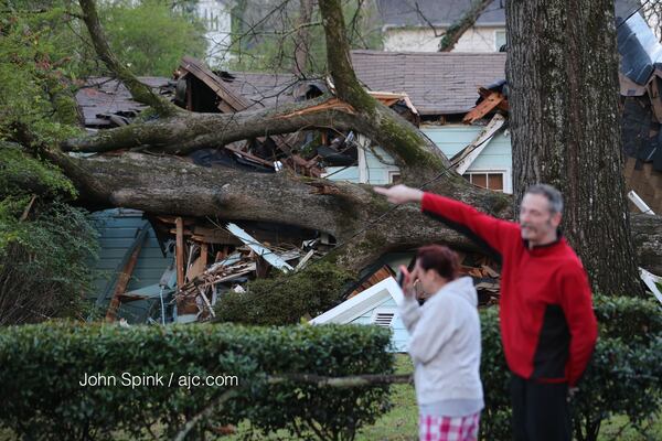 Mendy Furlong and neighbor Burt Brown assess the damage at her home. JOHN SPINK / JSPINK@AJC.COM