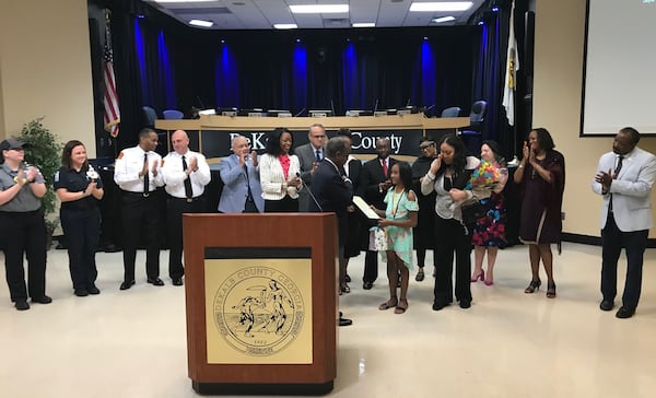 DeKalb County CEO Michael Thurmond presents a proclamation to Jayla Dallis, a 10-year-old girl credited with saving her sister from a near-drowing. Her mom Daneshia Dallis dabs away tears as school system officials, public safety officers and county commissioners applaud. TIA MITCHELL/TIA.MITCHELL@AJC.COM