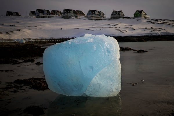 A piece of ice is photographed melting at the shore of a beach in Nuuk, Greenland, Friday, Feb. 14, 2025. (AP Photo/Emilio Morenatti)