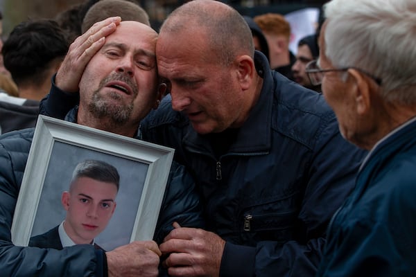 Dragi Stojanov, left, cries holding a photograph of his son Tomche Stojanov, one of the victims of a massive nightclub fire, during a vigil joined by hundreds in the town of Kocani, North Macedonia, Monday, March 17, 2025. (AP Photo/Visar Kryeziu)