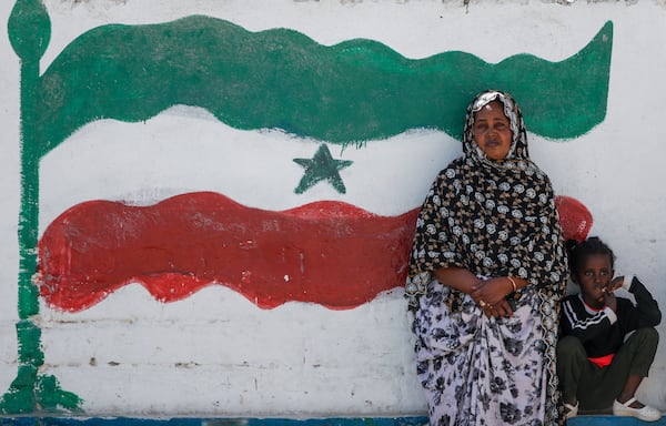 FILE - A woman and child relax next to a mural of Somaliland's flag, in Hargeisa, Somaliland, a semi-autonomous breakaway region of Somalia, on Feb. 9, 2022. (AP Photo/Brian Inganga, File)