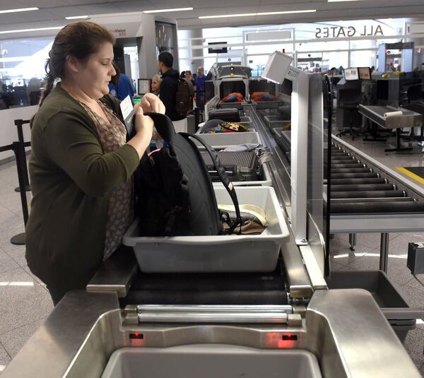 June 5, 2019 Atlanta - A traveler grabs her belongings at the new TSA smart lane at the international terminal at Hartsfield-Jackson Airport. Two new TSA smart lanes at the international terminal at Hartsfield-Jackson are aimed at making it easier for travelers to get through screening. And at the end of screening, passengers can leave their empty bins on the belt instead of stacking them at the end. The new lanes are equipped with CT machines, which allow passengers to keep all items in their bags instead of removing them and putting them into bins. The conveyor belt automatically feeds the empty bins into a stack and shuttles them to the front of the line to be reused. RYON HORNE/RHORNE@AJC.COM