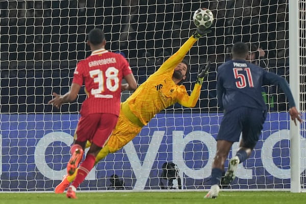 Liverpool's goalkeeper Alisson makes a save during the Champions League round of 16 first leg soccer match between Paris Saint-Germain and Liverpool at the Parc des Princes in Paris, Wednesday, March 5, 2025. (AP Photo/Aurelien Morissard)