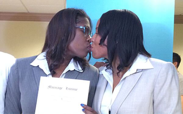 Emma Foulkes, left, and Petrina Bloodworth of Atlanta get married in the Fulton County Courthouse as their son Raimus Foulkes watches at left, on June 26, 2015. The couple has been together for ten years. Theirs was the first same-sex marriage licensed in Fulton, and it occurred only minutes after the Supreme Court’s decision legalizing same-sex marriage in all states. (DAVID WICKERT / DWICKERT@AJC.COM)