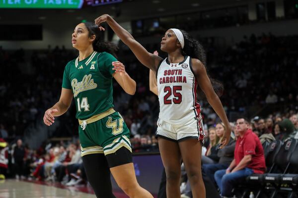 South Carolina guard Raven Johnson (25) makes a 3-pointer over South Florida forward Ines Piper (14) during the second half of an NCAA college basketball game Sunday, Dec. 15, 2024, in Columbia, S.C. (AP Photo/Artie Walker Jr.)