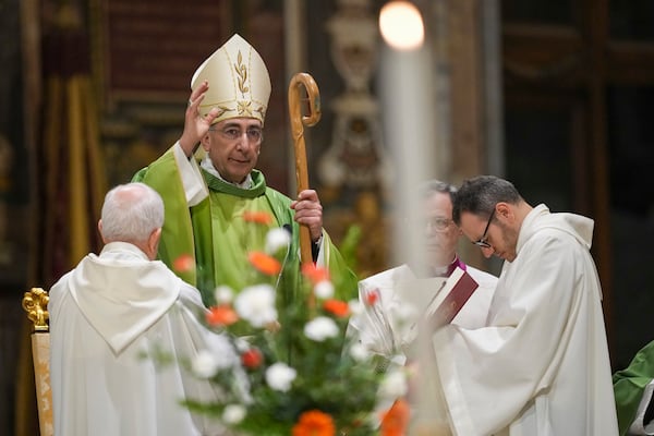 Pope's vicar general of the Diocese of Rome, Cardinal Baldassarre Reina, center, blesses the faithful at the end of mass in St. John Lateran Basilica in Rome Sunday, Feb. 23, 2025, to pray for Pope Francis who was admitted over a week ago at Rome's Agostino Gemelli Polyclinic and is in critical condition. (AP Photo/Alessandra Tarantino)