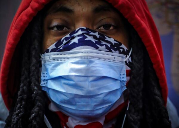 In this April 7, 2020, photo, a subway rider wears a mask and a bandana to protect himself against COVID-19 in New York. As the coronavirus tightened its grip across the country, it is cutting a particularly devastating swath through an already vulnerable population, black Americans. (AP Photo/Bebeto Matthews)