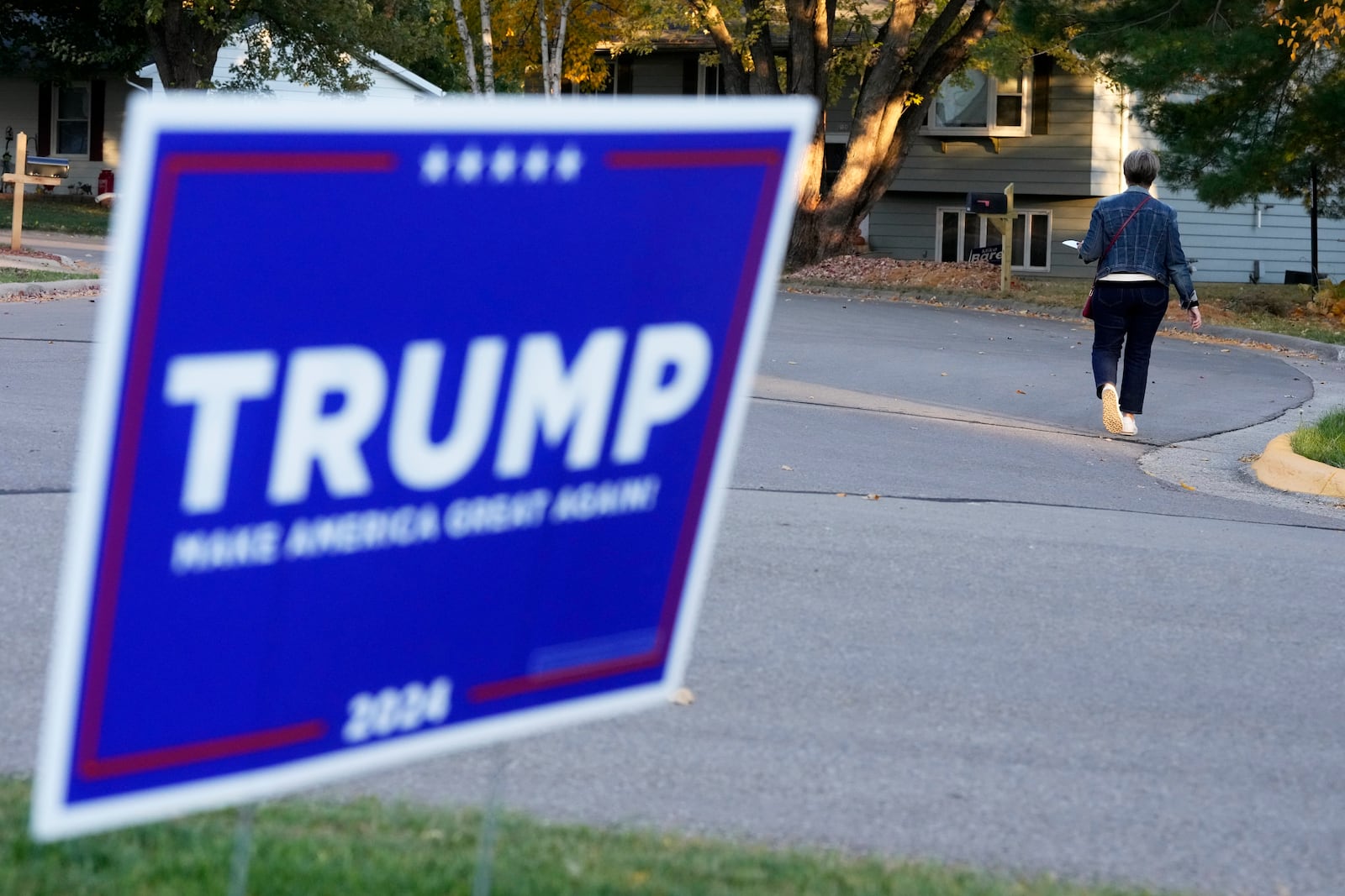 Kathy Moran canvases houses Wednesday, Oct. 23, 2024, in Cross Plains, Wis. (AP Photo/Morry Gash)