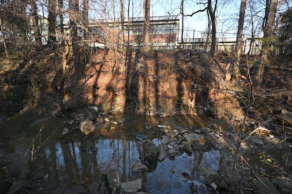 An unnamed tributary (foreground) that runs between the TAV Holdings site and the back of Crawford W. Long Middle School (background) is shown. EPA analysis shows pollutants from the TAV site are entering the creek, which connects to the South River. 