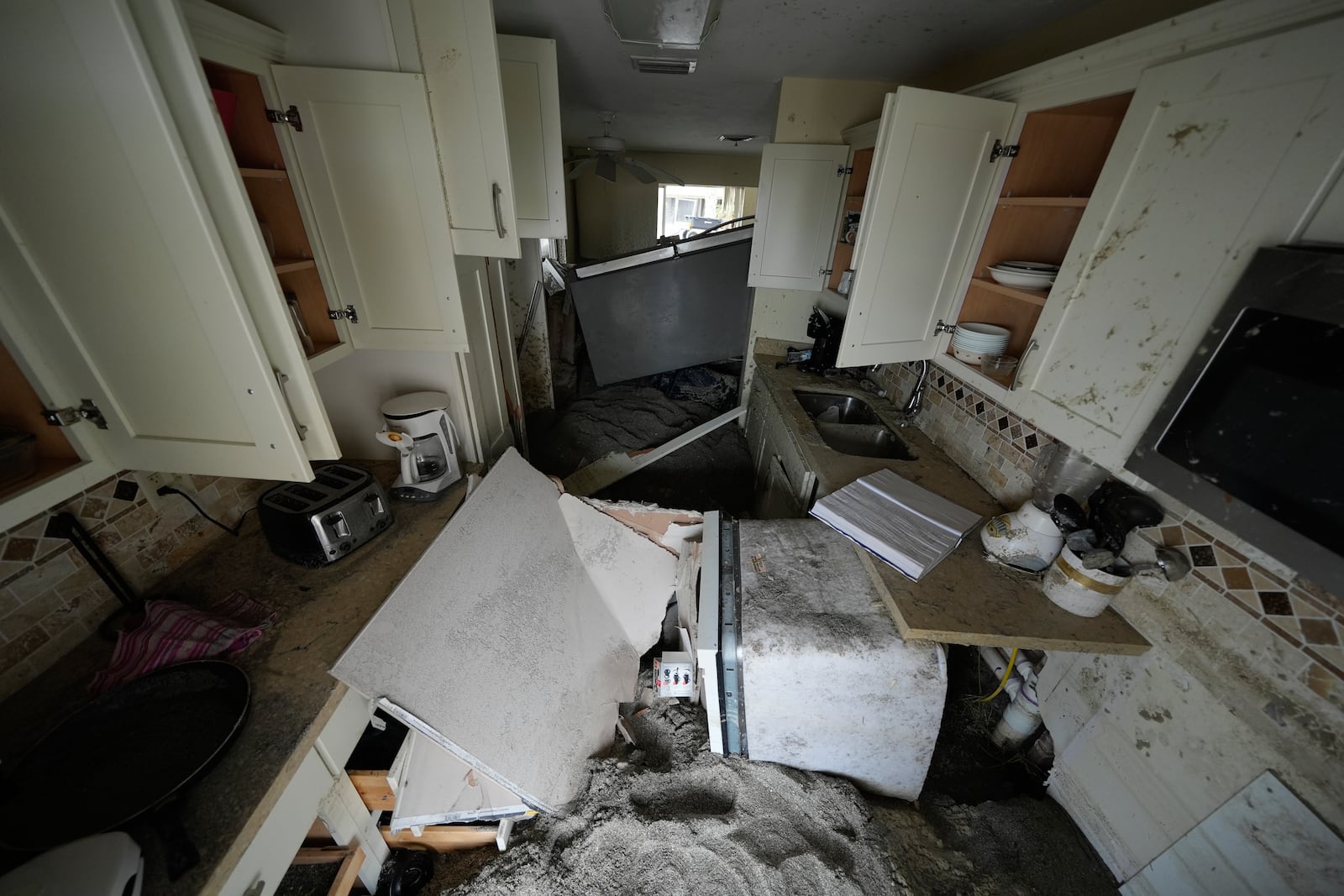 Several feet of sand fills a condo following the passage of Hurricane Milton, at YCA Vacation Rentals in Venice, Fla., Friday, Oct. 11, 2024. (AP Photo/Rebecca Blackwell)