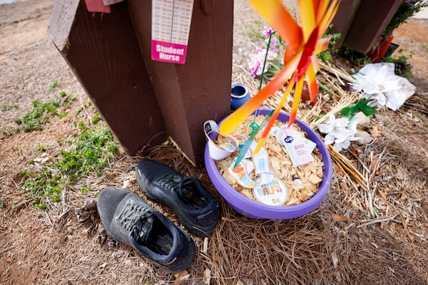 Multiple items are displayed at the Herrick Park sign in memory of Laken Riley on Tuesday, Feb. 18, 2025. (Miguel Martinez/ AJC)