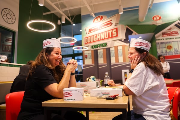 Christa Gogstad (left) and Gloria Woodward-Glasser enjoy breakfast during the grand reopening of Krispy Kreme on Ponce De Leon Avenue. (Arvin Temkar / arvin.temkar@ajc.com)