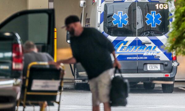 A patient is helped from a vehicle at the emergency entrance at Wellstar Atlanta Medical Center on Boulevard in Atlanta on Wednesday. Statewide, nearly a third of all hospitalized patients — totaling 5,327 — were being treated for COVID-19. That is a drop from the pandemic peak of just over 6,000 two weeks ago. (John Spink / John.Spink@ajc.com)


