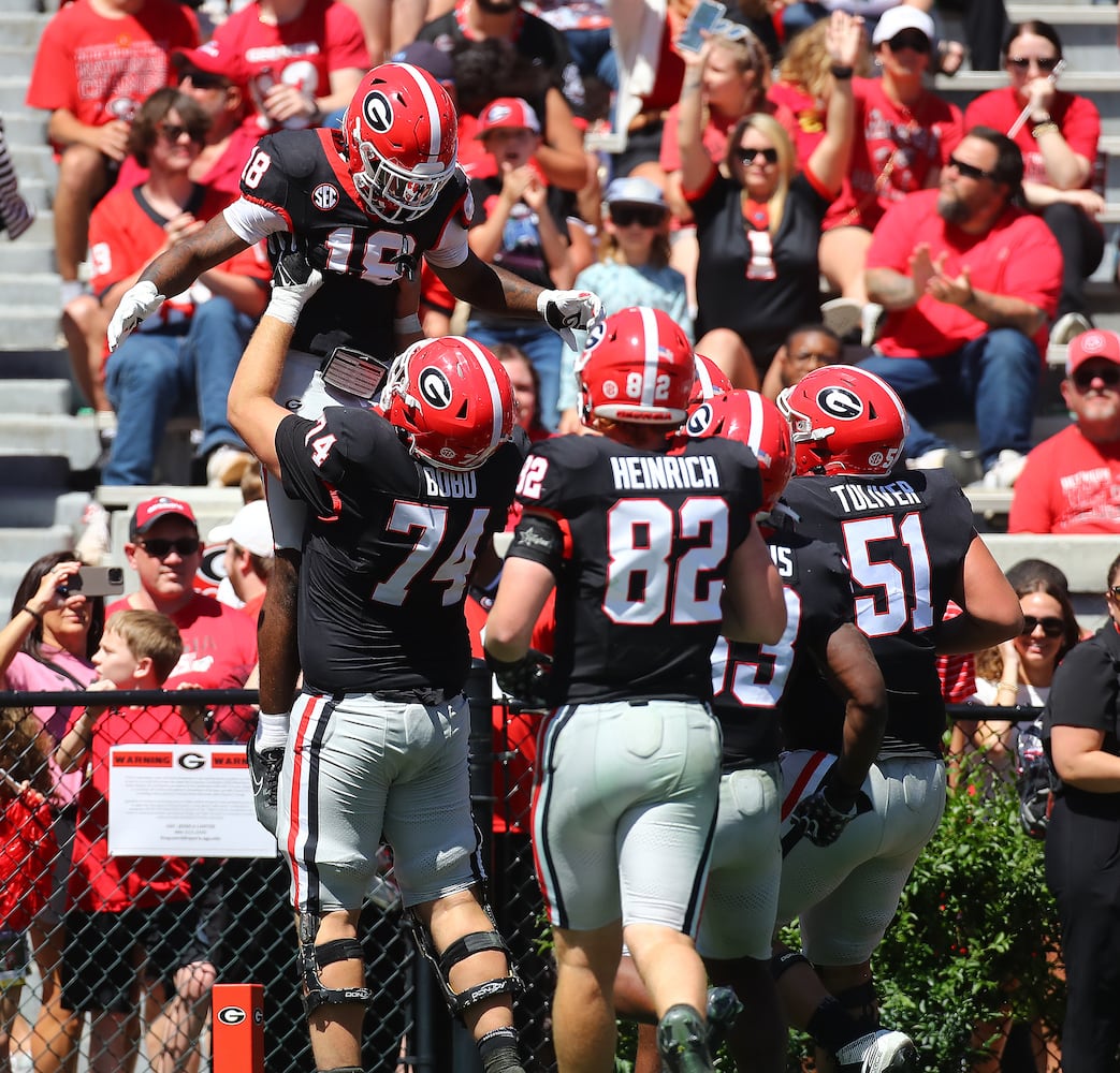 Wide receiver Sacovie White gets a hoist in the end zone from offensive lineman Drew Bobo after scoring a touchdown to give the black team a 17-13 lead during the G-Day game on Saturday, April 13, 2024.  Curtis Compton for the Atlanta Journal Constitution