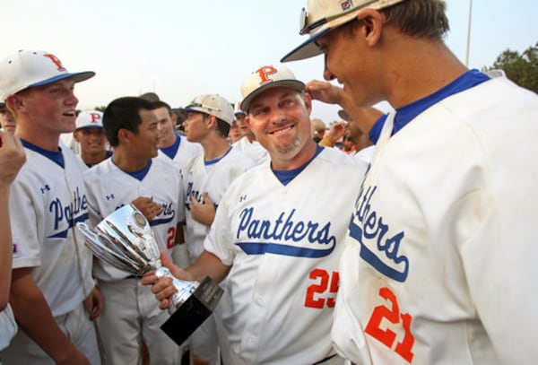 Parkview head coach Chan Brown, center, holds the state trophy as he celebrates with first baseman Matt Olson, right, after Parkview's 6-3 win against Brookwood in game two to win the Class AAAAA baseball championships at Parkview High School Saturday afternoon in Lilburn, Ga., May 26, 2012. Parkview has won the baseball championship in back-to-back years.