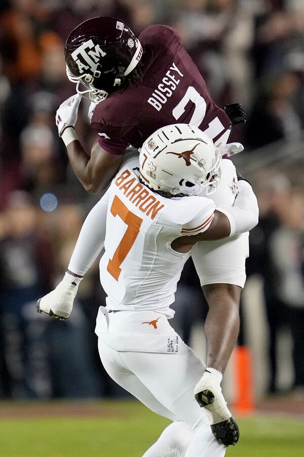 Texas A&M wide receiver Terry Bussey (2) catches a pass for a first down against Texas defensive back Jahdae Barron (7) during the first half of an NCAA college football game Saturday, Nov. 30, 2024, in College Station, Texas. (AP Photo/Sam Craft)