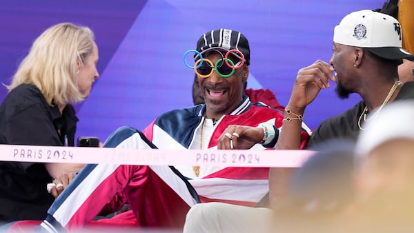 FILE - American artist Snoop Dogg, center, sits in the audience prior to the breaking competition at La Concorde Urban Park at the 2024 Summer Olympics, Friday, Aug. 9, 2024, in Paris, France. (AP Photo/Frank Franklin, File)