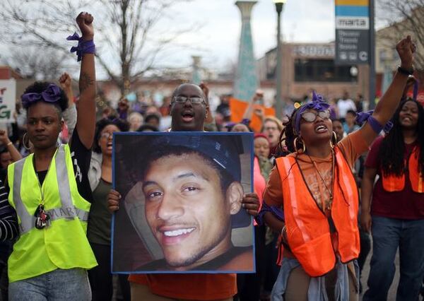 Protesters, including Brandan Marshall holding a photo of Anthony Hill, take to the streets of downtown Decatur to protest Hill’s shooting death on March 9, 2015. Hill was killed by a DeKalb police officer, who later was indicted in the shooting. BEN GRAY / BGRAY@AJC.COM