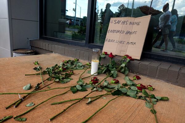 People are leaving flowers at a memorial down the street from Wendy's where Rayshard Brooks, a 27-year-old black man,  was shot and killed by Atlanta police Friday evening during a struggle with police in the drive-thru line.    Ben Gray for the Atlanta Journal Constitution