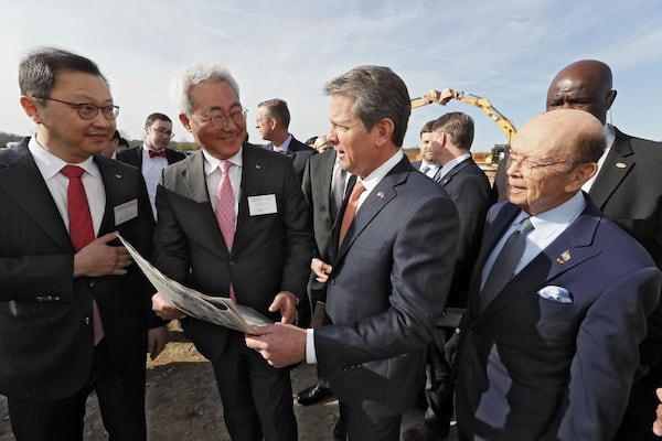 March 19, 2019 - Atlanta - SK Group Executive Vice Chairman Jaewon Chey, left, SK Innovation President and CEO Jun Kim, Gov. Brian Kemp, and U.S. Secretary of Commerce Wilbur Ross look over a full page ad in Monday’s Atlanta Journal-Constitution promoting SK Innovation’s planned battery plant in Jackson County. The South Korean conglomerate broke ground Tuesday on a new nearly $1.7 billion battery plant in Jackson County, one of the largest single economic development projects in the state’s history and one that will bring a significant foreign investment — and 2,000 jobs. Bob Andres / bandres@ajc.com