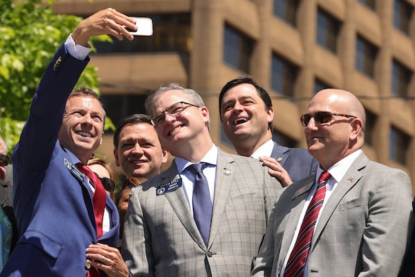 Sen. Greg Dolezal, R-Cumming, holds up his camera to take a selfie with legislators while waiting for Gov. Brian Kemp to arrive to sign Senate Bill 233 known as the Georgia Promise Scholarship Act at Liberty Plaza in April. Natrice Miller/AJC 2024