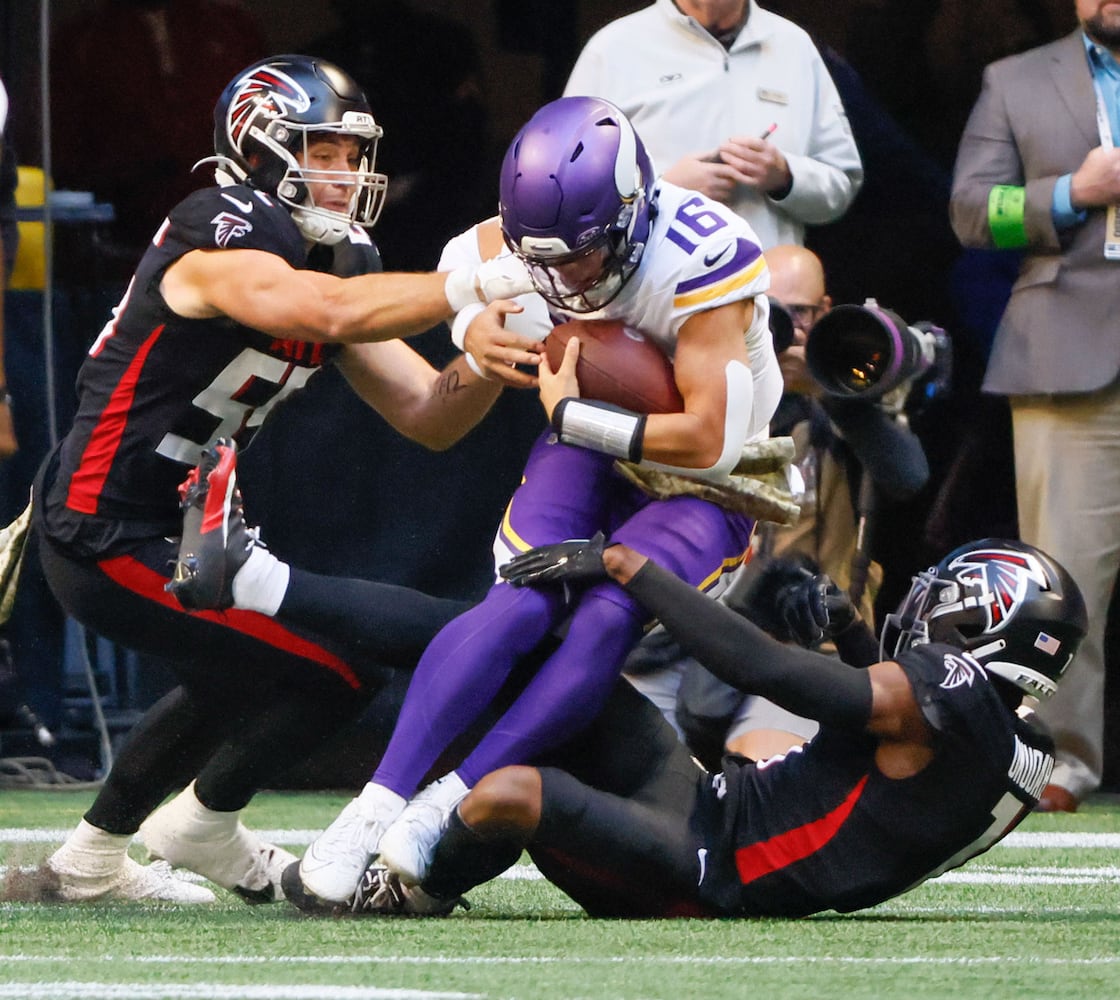 Minnesota Vikings quarterback Jaren Hall (16) is stopped on a scramble during the Falcons goal line stand by Atlanta Falcons linebacker Kaden Elliss (55) and cornerback Jeff Okudah (1) in the first quarter of an NFL football game in Atlanta on Sunday, Nov. 5, 2023. (Bob Andres for the Atlanta Journal Constitution)