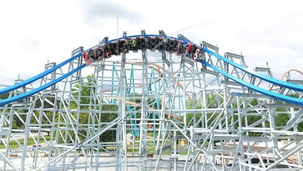 This image provided by Six Flags Over Georgia in Austell, Ga., shows the new Twisted Cyclone roller coaster. The hybrid roller coaster combines a traditional wood coaster structure with a steel track. The red and black train is modeled after a classic 1960s sports car. It's one of a number of new attractions at theme parks around the country this season. (Six Flags via AP)