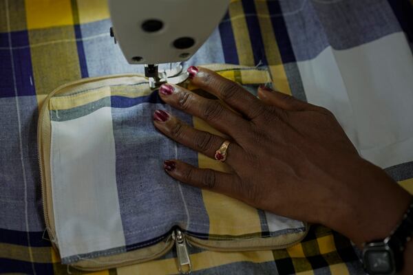 H. Gauri, 32, uses an electric sewing machine to stitch a cloth pouch in a small garage, at the campus of the Swami Vivekananda Youth Movement, a nongovernmental organization that works to help poor and Indigenous communities, in Kenchanahalli, India, Monday, Sept. 23, 2024. (AP Photo/Aijaz Rahi)