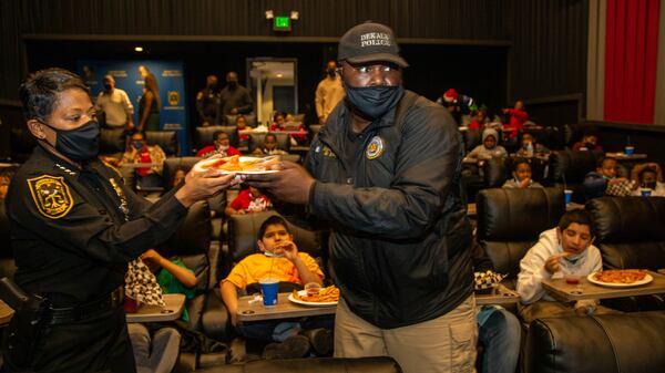 Police Chief Mirtha Ramos (left) and Detective Khary Ricksetts help pass out food during the community outreach event.