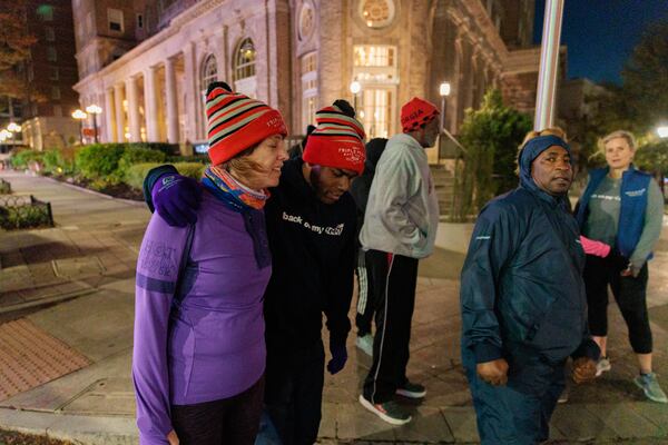 Runners with Back on My Feet Atlanta pause at a stop light in Atlanta early in the morning on Wednesday, November 16, 2022. The nonprofit helps people who are homeless and struggling with addiction build confidence, accountability and other life skills through running. (Arvin Temkar / arvin.temkar@ajc.com)