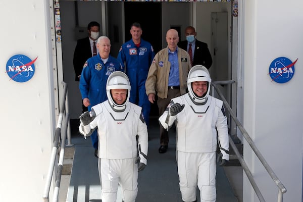 NASA astronauts Douglas Hurley, left, and Bob Behnken walk out of the Neil A. Armstrong Operations and Checkout Building.