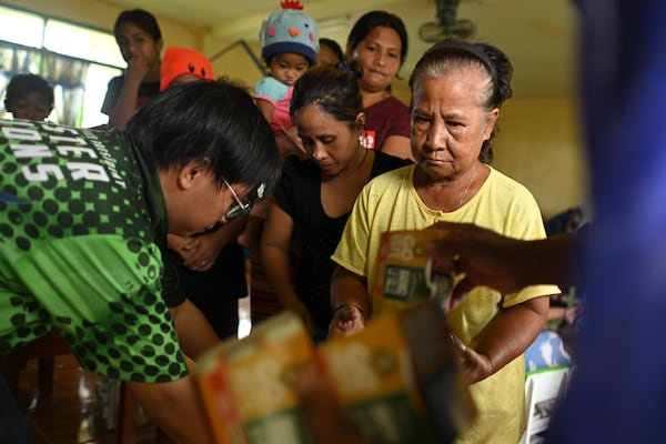 Residents receive relief goods at a school used as an evacuation center in Santa Ana, Cagayan province, northern Philippines as Typhoon Usagi approaches Thursday, Nov. 14, 2024. (AP Photo/Noel Celis)