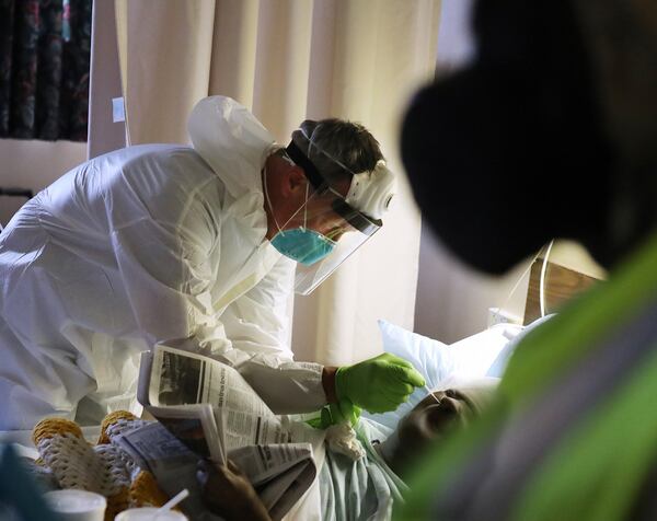 Dr. Stephen Smith of Piedmont Healthcare collects swabs from Legacy Transitional Care & Rehabilitation residents to test for the novel coronavirus, with assistance from Georgia Army National Guard infection control member Pfc. Cierra Williams (far right at the doorway) on April 19. Curtis Compton ccompton@ajc.com