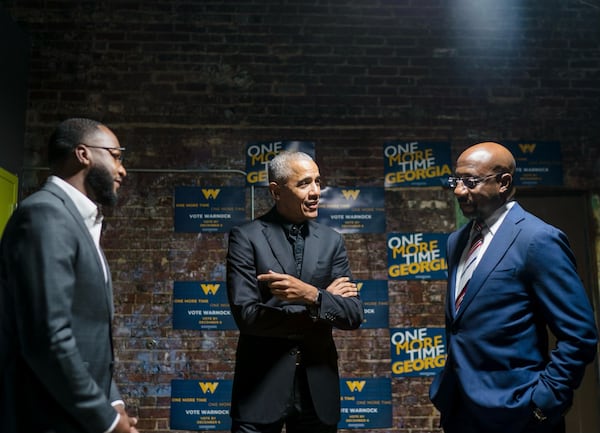 Former President Barack Obama shares a moment with U.S. Sen. Raphael Warnock (right) and campaign manager Quentin Fulks during a rally at Pullman Yard in Atlanta, GA, on December 1, 2022. Photo by Kevin Lowery.