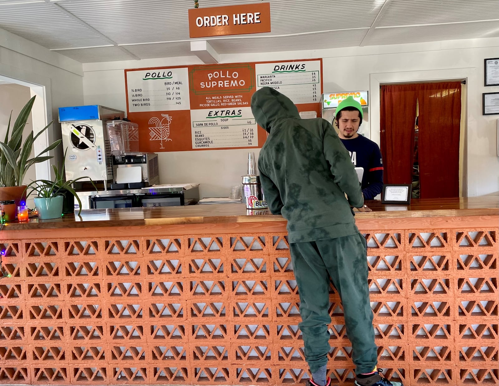 A cashier takes an order at Pollo Supremo on Moreland Avenue on a Sunday afternoon. Wendell Brock for The Atlanta Journal-Constitution