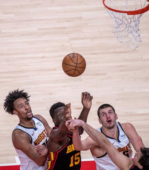 Hawks center Clint Capela (15) successfully fights for a rebound against the Denver Nuggets during the first quarter Sunday, Feb. 21, 2021, at State Farm Arena in Atlanta. (Alyssa Pointer / Alyssa.Pointer@ajc.com)