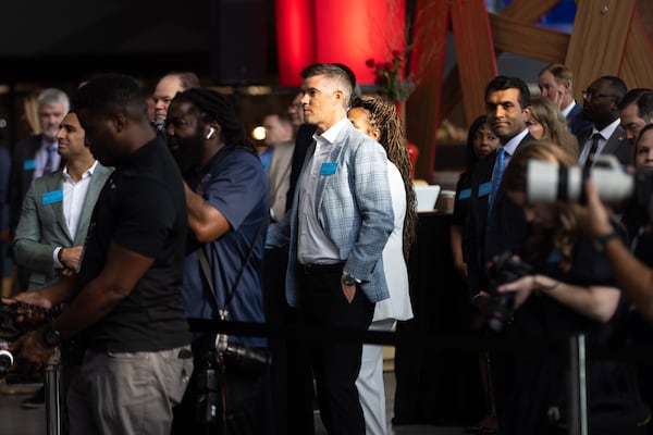 Onlookers are seen before Gov. Brian Kemp remotely rings the New York Stock Exchange opening bell from Mercedes-Benz Stadium in Atlanta on Friday, September 1, 2023, ahead of the inaugural Aflac Kickoff Game. It’s the first time the NYSE opening bell has been rung from the state of Georgia. (Arvin Temkar / arvin.temkar@ajc.com)