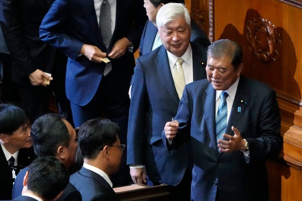 Japanese Prime Minister Shigeru Ishiba, right, speaks with other lawmakers at a special parliamentary session of the lower house Monday, Nov. 11, 2024, in Tokyo. (AP Photo/Eugene Hoshiko)