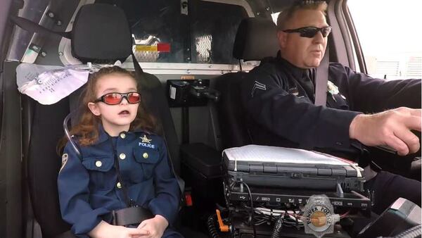 Olivia Gant goes on a ride with a Denver police officer in a still from video shot in April 2017, about four months before the 7-year-old's death. Her mother, Kelly Turner, is accused of lying about the girl's health for years before killing her.