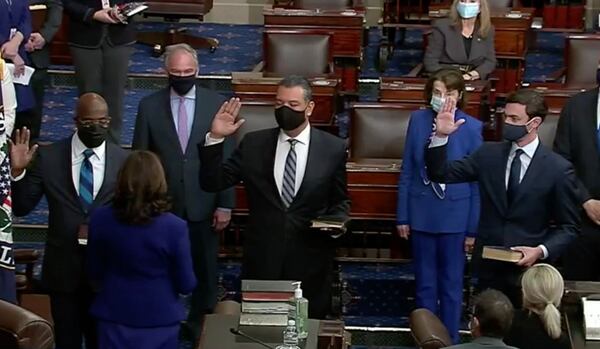 Georgia’s Rev. Raphael Warnock, left, and Jon Ossoff, right, are sworn into the Senate along with Alex Padilla of California on Wednesday, Jan. 20, 2021. (Video image from C-SPAN)