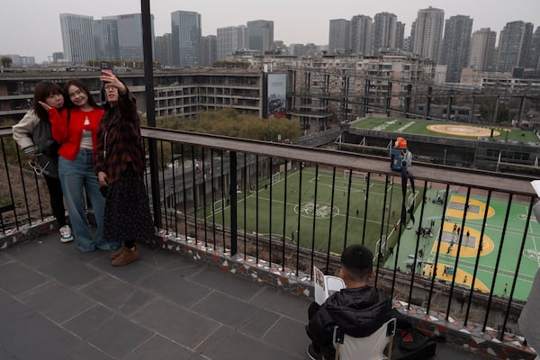 Visitors pose for photos at the West Village project by Pritzker Architecture Prize winner Chinese architect Liu Jiakun in Chengdu in southwestern China's Sichuan province on Sunday, March 2, 2025. (AP Photo/Ng Han Guan)