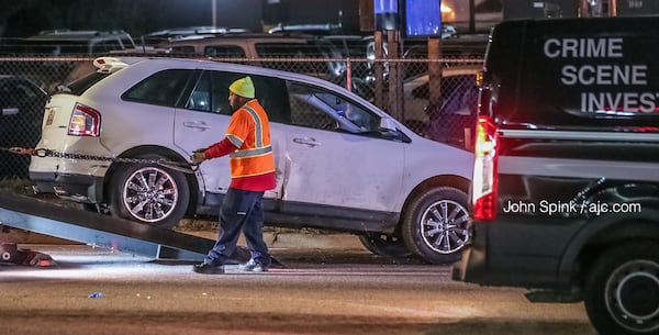 A white Ford is towed from the scene of a crash on Covington Highway in DeKalb County. Its driver led officers on a chase through three metro Atlanta counties early Thursday morning. JOHN SPINK / JSPINK@AJC.COM