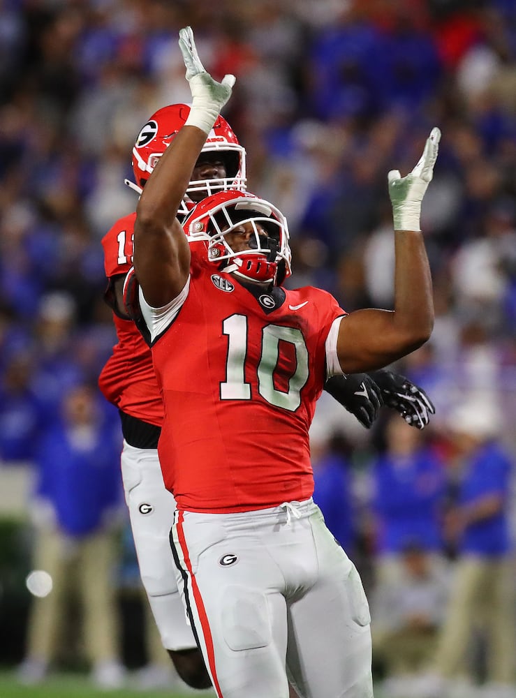 Georgia defenders Jamon Dumas-Johnson (10) and Kamari Lassiter celebrate after sacking Kentucky quarterback Devin Leary for a loss during the second quarter in a NCAA college football game on Saturday, Oct. 7, 2023, in Athens.  Curtis Compton for the Atlanta Journal Constitution