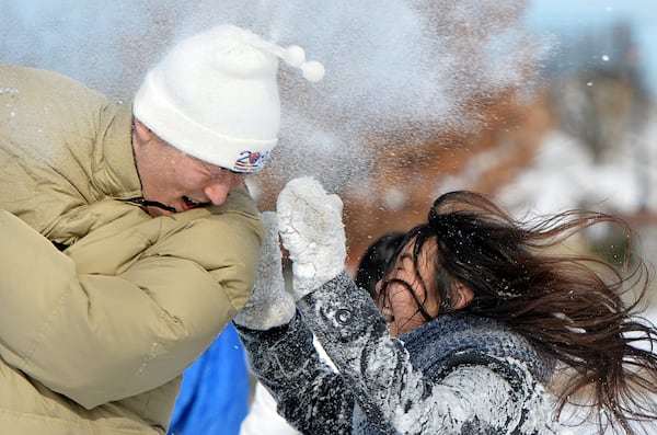 Patrick Kim (left) and Yoojin Park enjoy a snowball fight at Town Center Park in Suwanee on January 29, 2014. (HYOSUB SHIN / hshin@ajc.com)