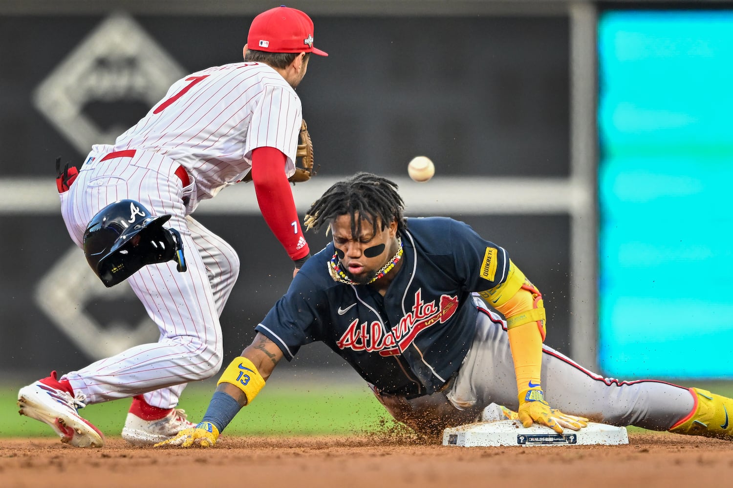 Atlanta Braves’ Ronald Acuna Jr. (13) slides safely into second base on a double ahead of the throw to Philadelphia Phillies shortstop Trea Turner (7) during the third inning of NLDS Game 3 in Philadelphia on Wednesday, Oct. 11, 2023.   (Hyosub Shin / Hyosub.Shin@ajc.com)