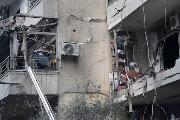 A man throws debris from his damaged apartment which was resulted from Sunday's Israeli airstrike in Dahiyeh, in the southern suburb of Beirut, Lebanon, Monday, Nov. 25, 2024. (AP Photo/Hussein Malla)